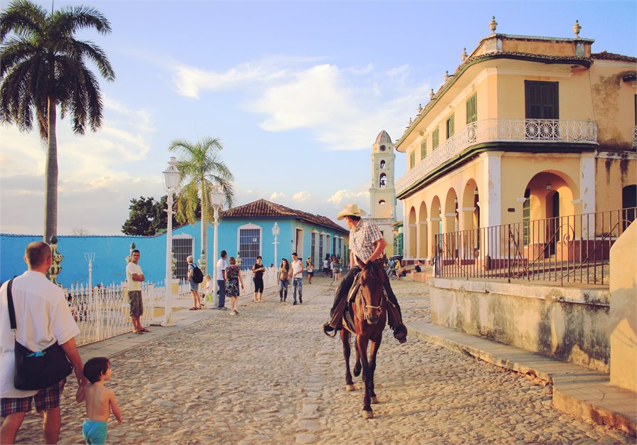 Cuban street man riding donkey old buildings